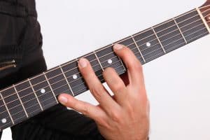 Guitarist with wide reach illustrating the CAGED Guitar System